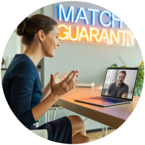 Woman in a blue dress on a video call with a man on a laptop at a desk, neon 'MATCH GUARANTEE' sign in the background.