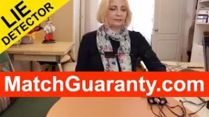 Woman seated at a desk with a polygraph lie detector on the table, yellow 'LIE DETECTOR' banner and red 'MatchGuaranty.com' overlay across the image.